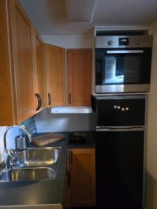 a kitchen with a sink and a microwave at Small cozy basement apartment in Sundsvall +11 photos
