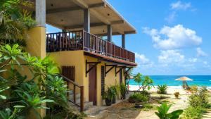 a building on the beach with the ocean in the background at Samadhi by the Venus Project in Ranna