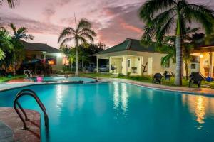 a large blue swimming pool in front of a house at Paradiso Hotel in Dar es Salaam