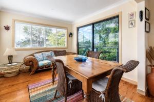 a living room with a wooden table and chairs at Waterfront Delight on Cater in Sussex Inlet