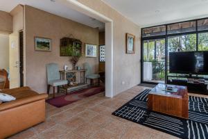 a living room with a couch and a flat screen tv at Waterfront Delight on Cater in Sussex Inlet