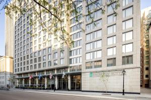 a large white building with american flags in front of it at Embassy Suites by Hilton - Montreal in Montreal +38 photos