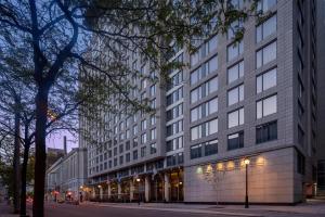 a large building on a city street with trees at Embassy Suites by Hilton - Montreal in Montreal