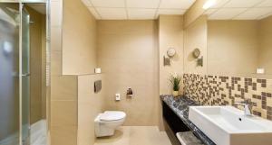 a bathroom with a toilet and a sink and a shower at Hotel Victor Pruszków DeSilva in Pruszków