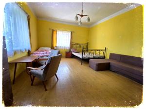 a living room with a couch and a bed and a table at Chalupa nad Dvorem in Slezské Pavlovice