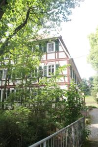 a pink house with a fence in front of it at Ferienwohnung Mühlradblick in Geismar