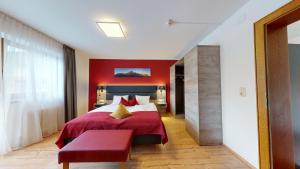a red bedroom with a bed and a red wall at Landhaus Wildschwendt in Ellmau