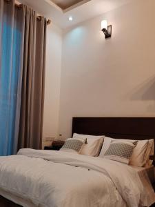 a bedroom with a large bed with white sheets and pillows at Geza Breeze Residence in Kigamboni +28 photos