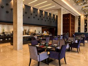 a restaurant with tables and chairs and a bar at Kiranshree Grand in Guwahati