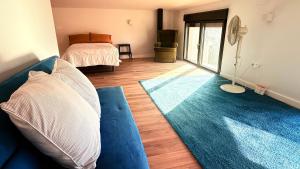 a living room with a blue couch and a bed at Casa Lia in Alcocer de Planes +26 photos
