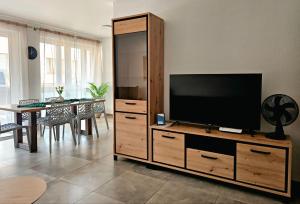 a living room with a flat screen tv on a wooden cabinet at Eibauer Apartments in Sinsheim