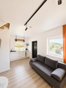 a living room with a couch and a kitchen at Sunrise Marina Domki Mielno- Ferienhaus in Mielenko