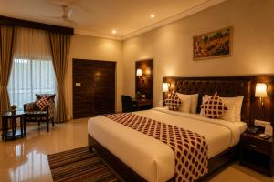 a hotel room with a bed and a chair at Jal Dhara Resort in Kumbhalgarh
