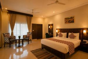 a hotel room with a bed and a table and chairs at Jal Dhara Resort in Kumbhalgarh