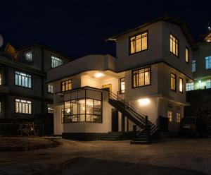 a large building with a staircase in front of it at night at Urbanest B&B in Shillong