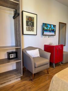 a living room with a chair and a red cabinet at Pousada Vila dos Santos in Porto De Galinhas