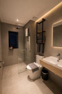 a bathroom with a toilet and a sink and a shower at One Studio Suite by PSH in Krong Poi Pet