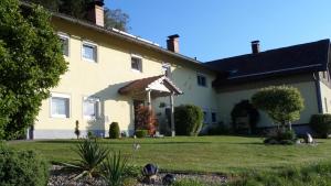 a large yellow house with a grass yard at FW & FH Lüsselfeld in Zwiesel
