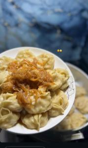 a plate of pasta with chicken and sauce on it at Abylay Guesthouse in Jangy-Talap