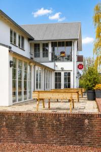 a wooden bench sitting in front of a building at Hotel De Brabantse Biesbosch in Werkendam