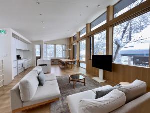a large living room with two couches and a kitchen at KOMU Hakuba in Hakuba