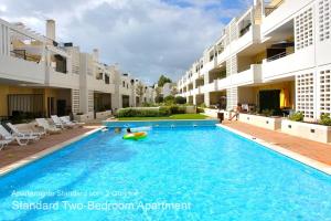 a swimming pool in the middle of a building at Akisol Cabanas Tavira Star in Cabanas de Tavira