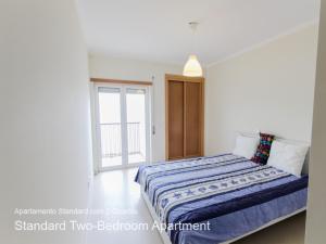 a bedroom with a bed with a blue blanket at Akisol Cabanas Tavira Star in Cabanas de Tavira