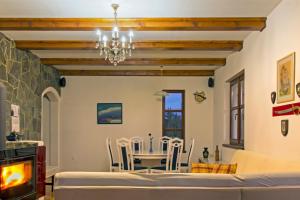 Vila Snjeguljica في Gorači: غرفة طعام مع طاولة وكراسي وثريا