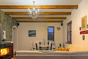 a dining room with a table and chairs and a chandelier at Vila Snjeguljica in Gorači