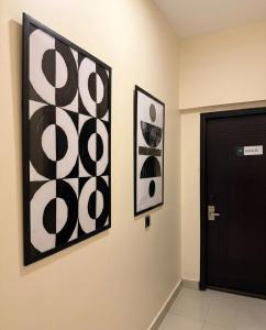 three black and white paintings on a wall next to a door at Hamsun Apart Hotel Clifton in Karachi +43 photos