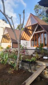 a small house with a tree in front of it at Prima Eco Cabin in Pabean Buleleng