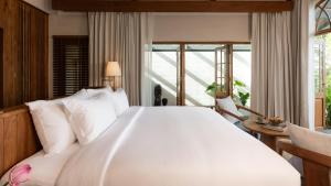a bedroom with a large white bed and a window at Siritarar Residence by Elite Havens in Nathon Bay