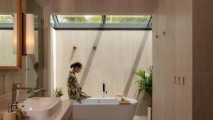 a person standing in a bath tub in a bathroom at Siritarar Residence by Elite Havens in Nathon Bay +24 photos