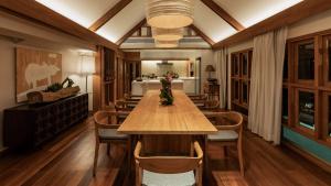 a dining room with a wooden table and chairs at Siritarar Residence by Elite Havens in Nathon Bay