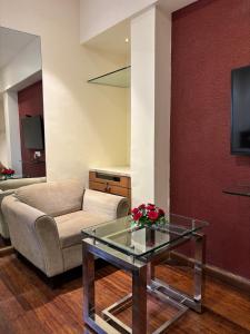 a living room with a couch and a glass table at Ramee Guestline Hotel Khar in Mumbai