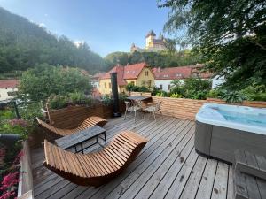 a wooden deck with chairs and a hot tub at Karlštejn 34 in Karlštejn