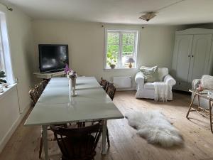 a living room with a table with chairs and a tv at Mysigt torp Cozy Cottage in Tranås