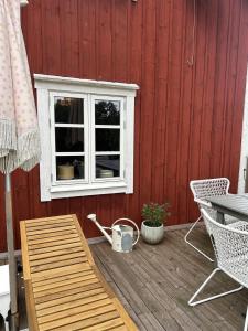 a deck with a window and a table and chairs at Mysigt torp Cozy Cottage in Tranås