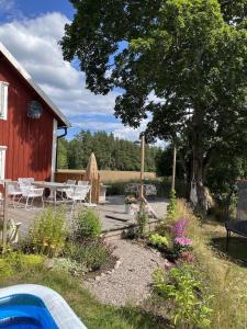 a garden with a table and chairs and a barn at Mysigt torp Cozy Cottage in Tranås
