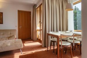 a living room with a table and chairs and a couch at Palanga Life Balance SPA Hotel in Palanga