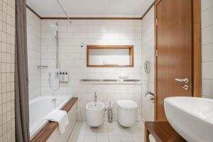 a bathroom with a tub and a toilet and a sink at Palanga Life Balance SPA Hotel in Palanga +64 photos