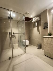 a bathroom with a glass shower and a toilet at Club Central in Bolpur +39 photos