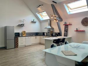 a kitchen with a table and a kitchen with skylights at Au Ptit MARIUS in Fécamp