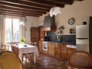 a kitchen with a table and a refrigerator at La maison de villars in Pressac