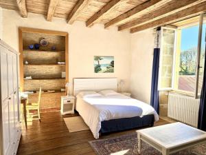a bedroom with a bed and a table and a window at La maison de villars in Pressac