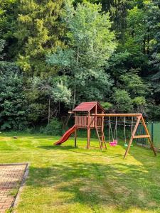 a playground with a swing set in a yard at Krásná pod Lysou horou in Krásná