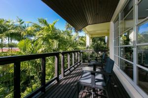 a balcony of a house with chairs and palm trees at Katamanda Aliya Pool & Jacuzzi Villa Kata in Kata Beach