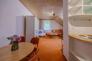 a kitchen and dining room with a table with a vase of flowers at Krásná pod Lysou horou in Krásná