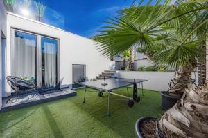 a patio with a table and a palm tree at Luxury TABOO Villa & Spa in Medulin for 8 people with heated pool & wellness area in Medulin