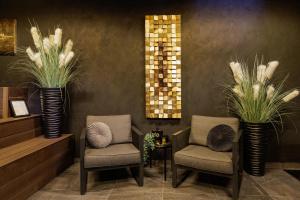 a lobby with two chairs and palm plants at Luxury TABOO Villa & Spa in Medulin for 8 people with heated pool & wellness area in Medulin